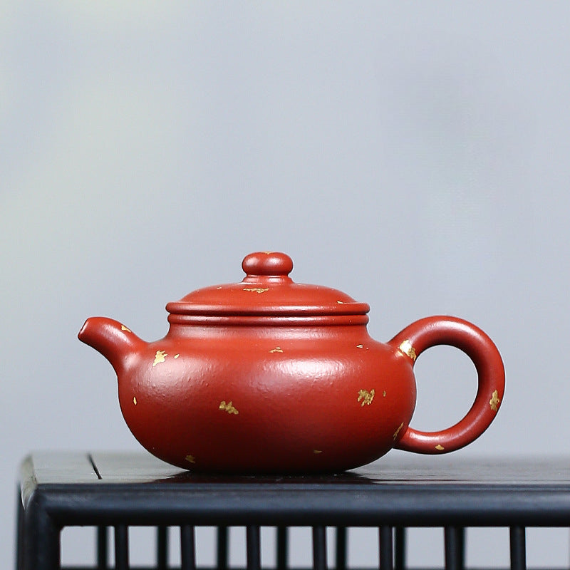The red, gold-painted teapot
