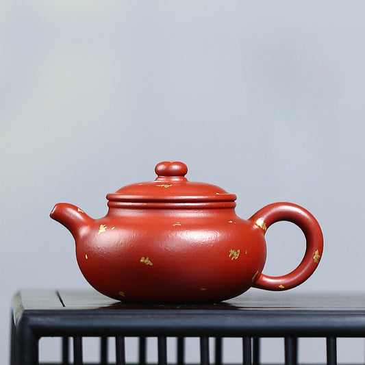 The red, gold-painted teapot